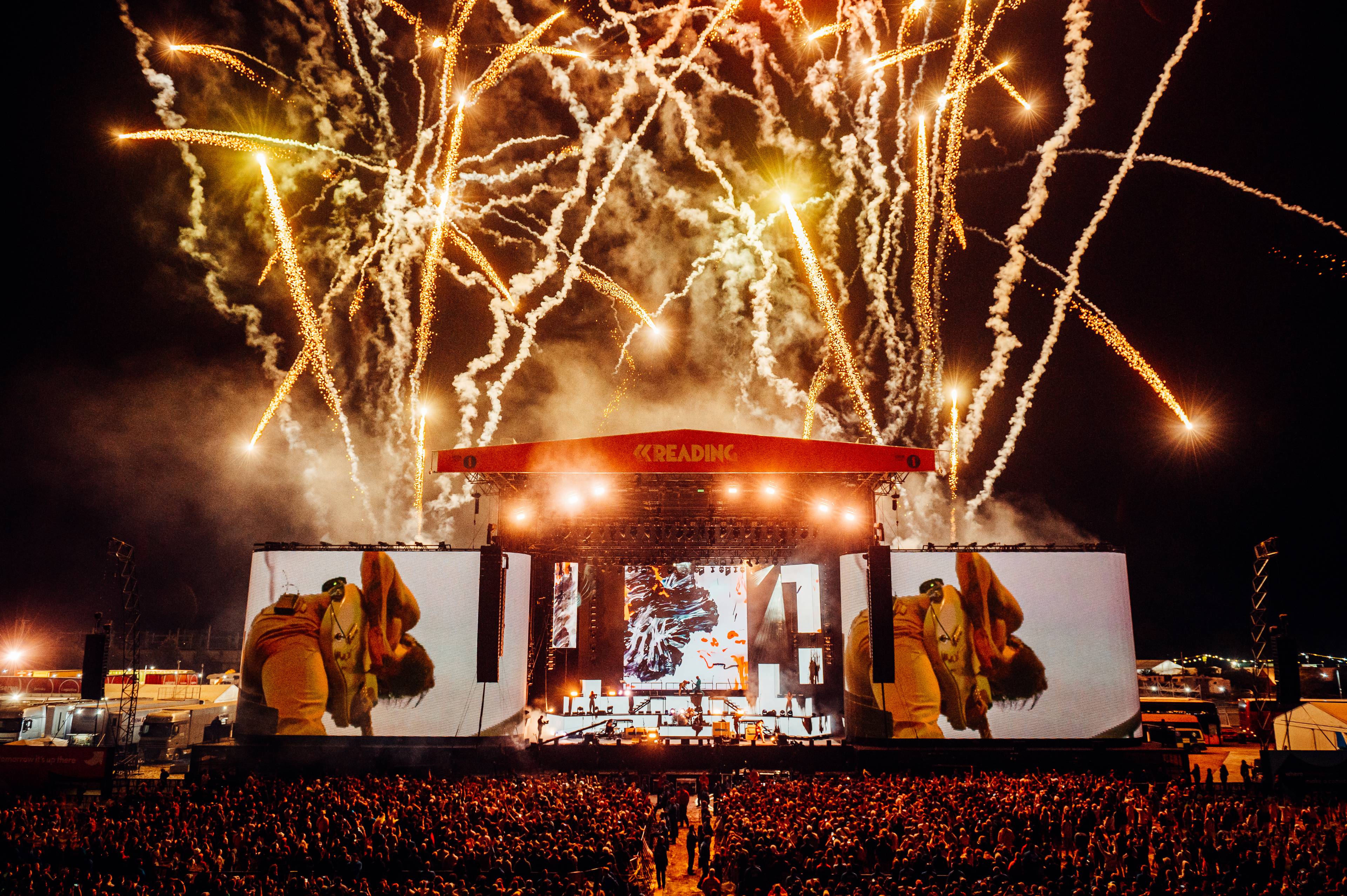 Reading festival stage at night with fireworks
