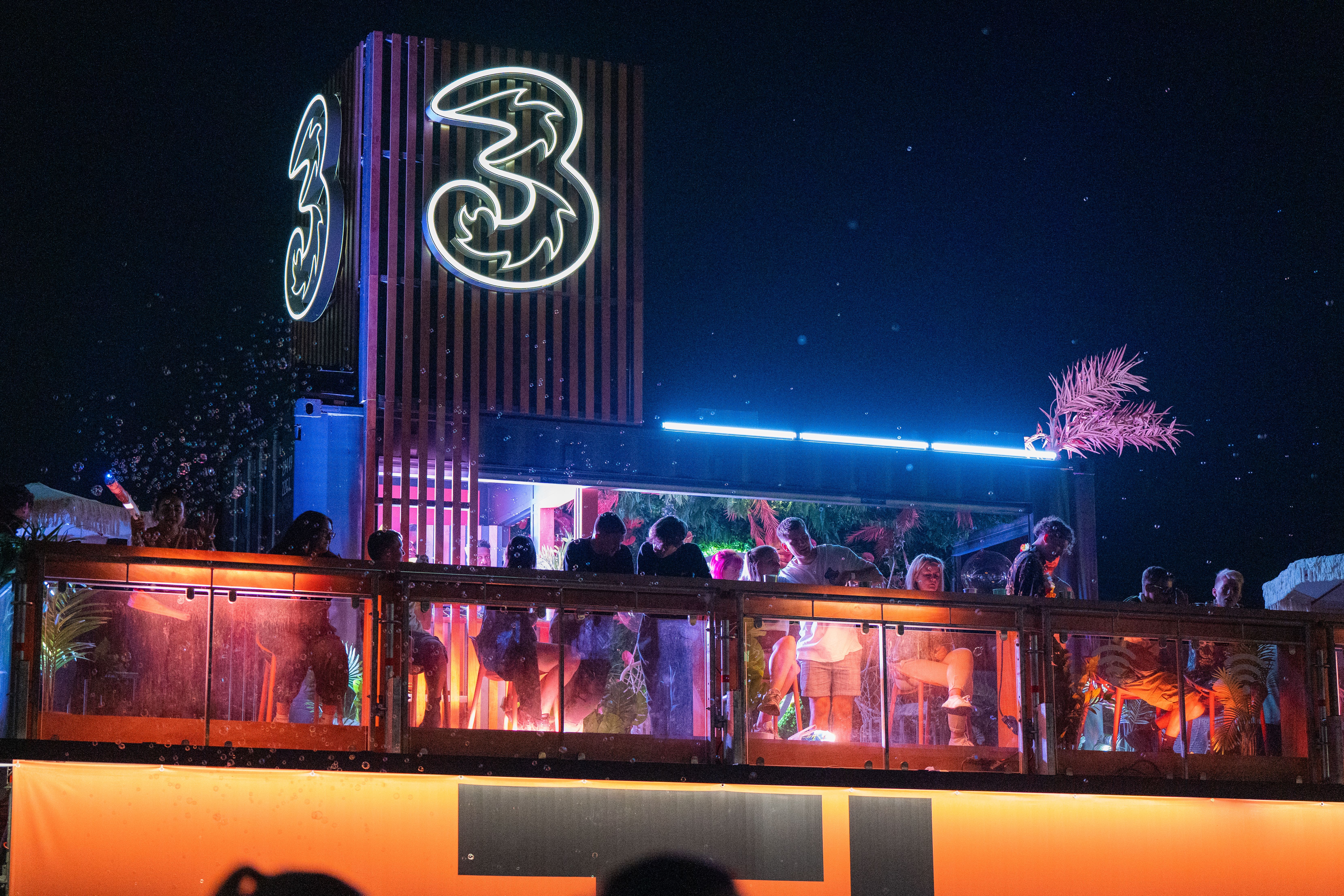 The Three Platform lit up at a festival at night