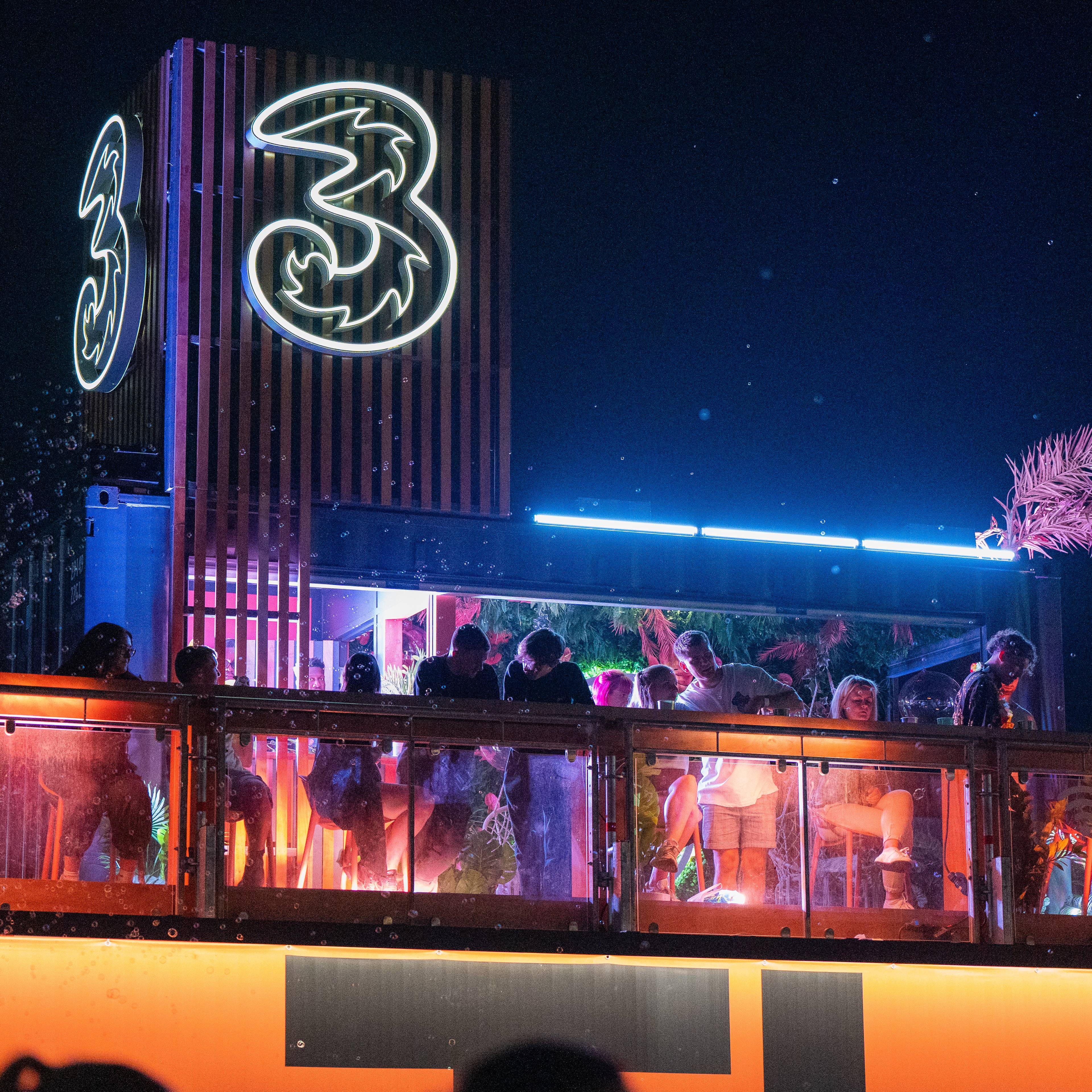The Three Platform lit up at a festival at night