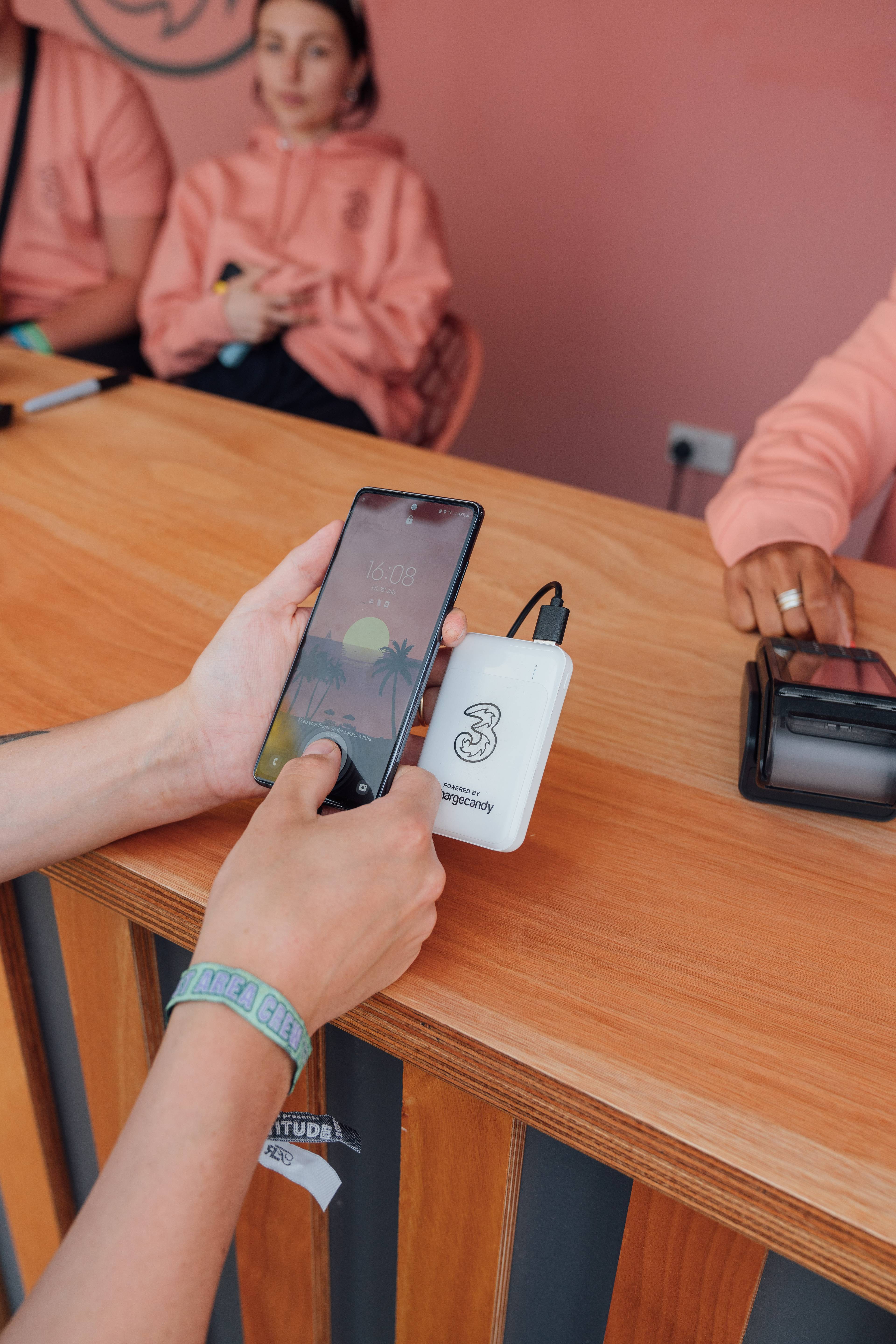 A person holding their phone attached to a portable charger