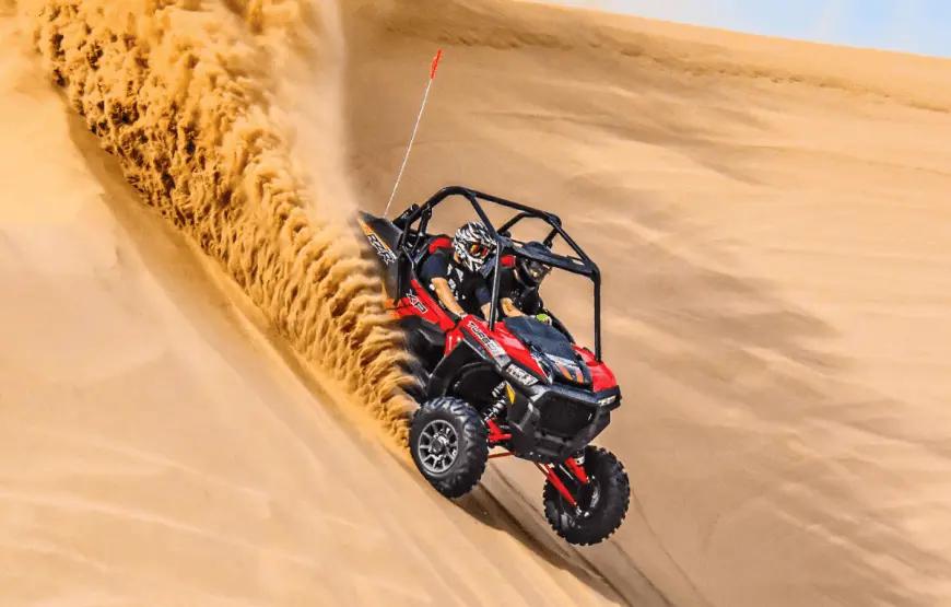Tourists driving a Polaris buggy through the Dubai desert