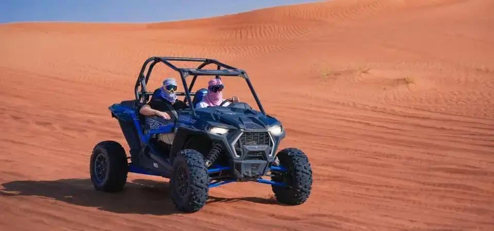 Couple smiling in a Polaris dune buggy in Dubai