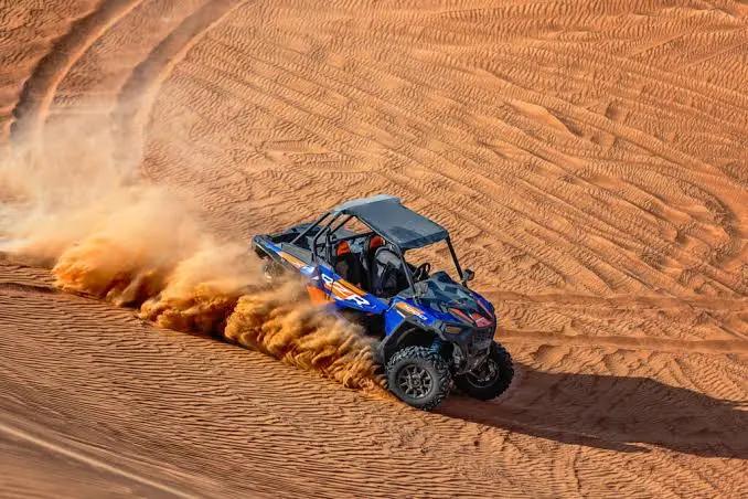 Sand kicking up behind a buggy on a Dubai desert tour
