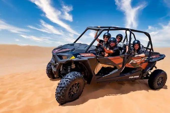 Parents and kids buckled into a four-seater dune buggy