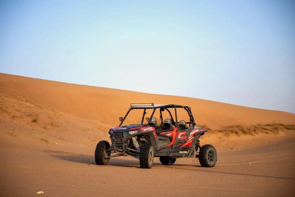 Close-up of a Polaris buggy kicking up sand