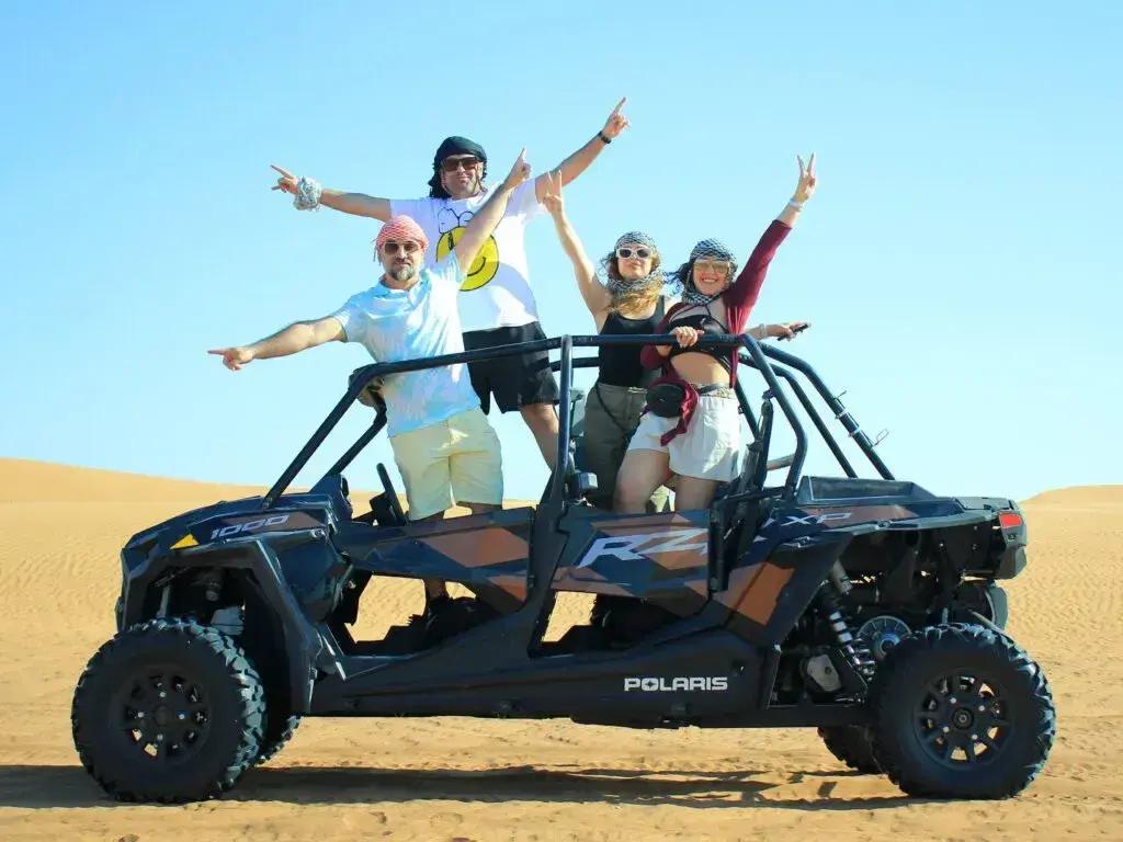 Family riding a 4-seater Polaris buggy through the Dubai desert