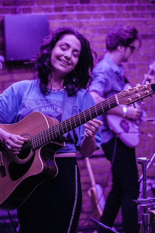 Naghmeh singing, with guitarist in background