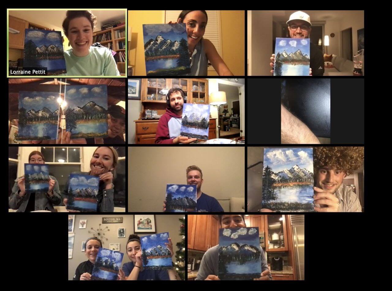 Team members holding landscape paintings of snowy mountains during virtual training session