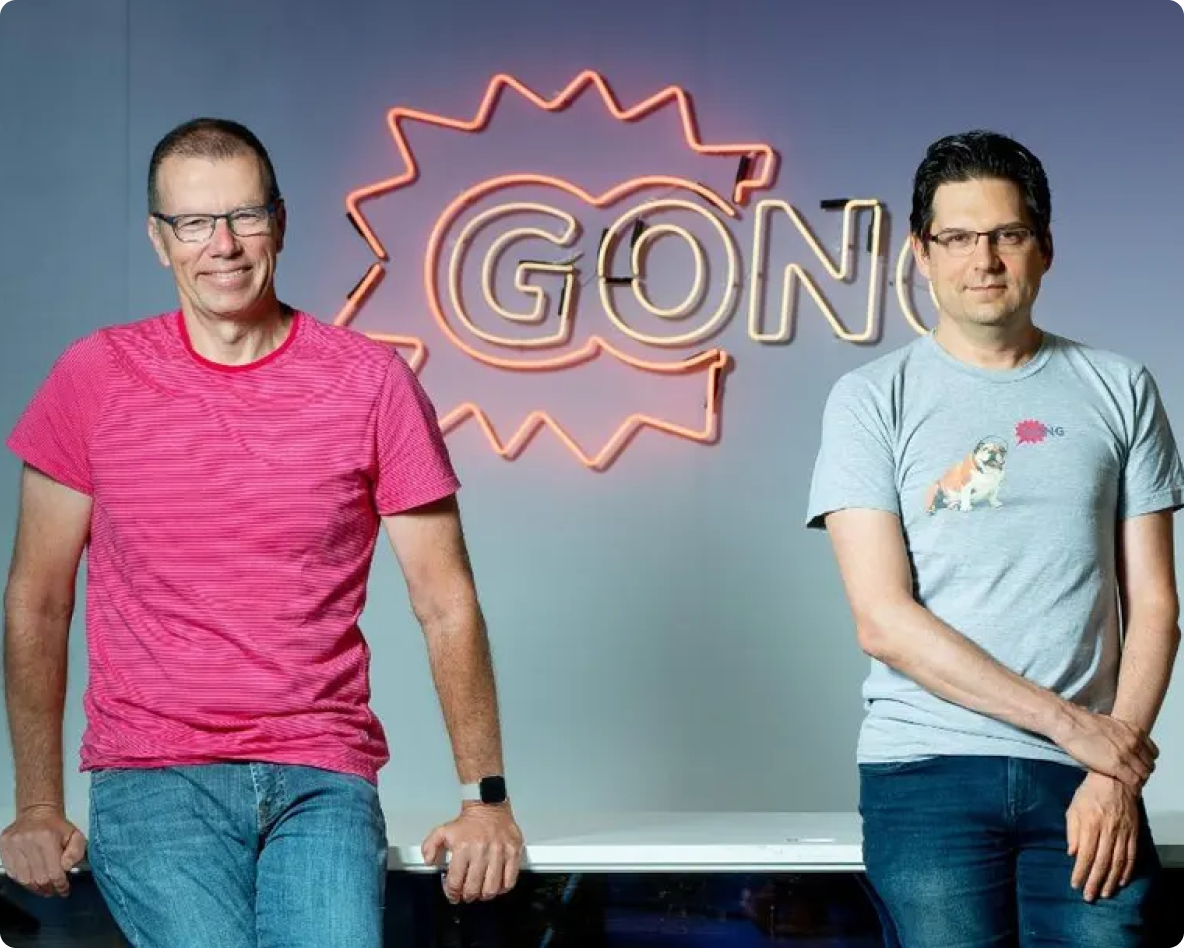 Two men standing in front of a sign that says "Gong"