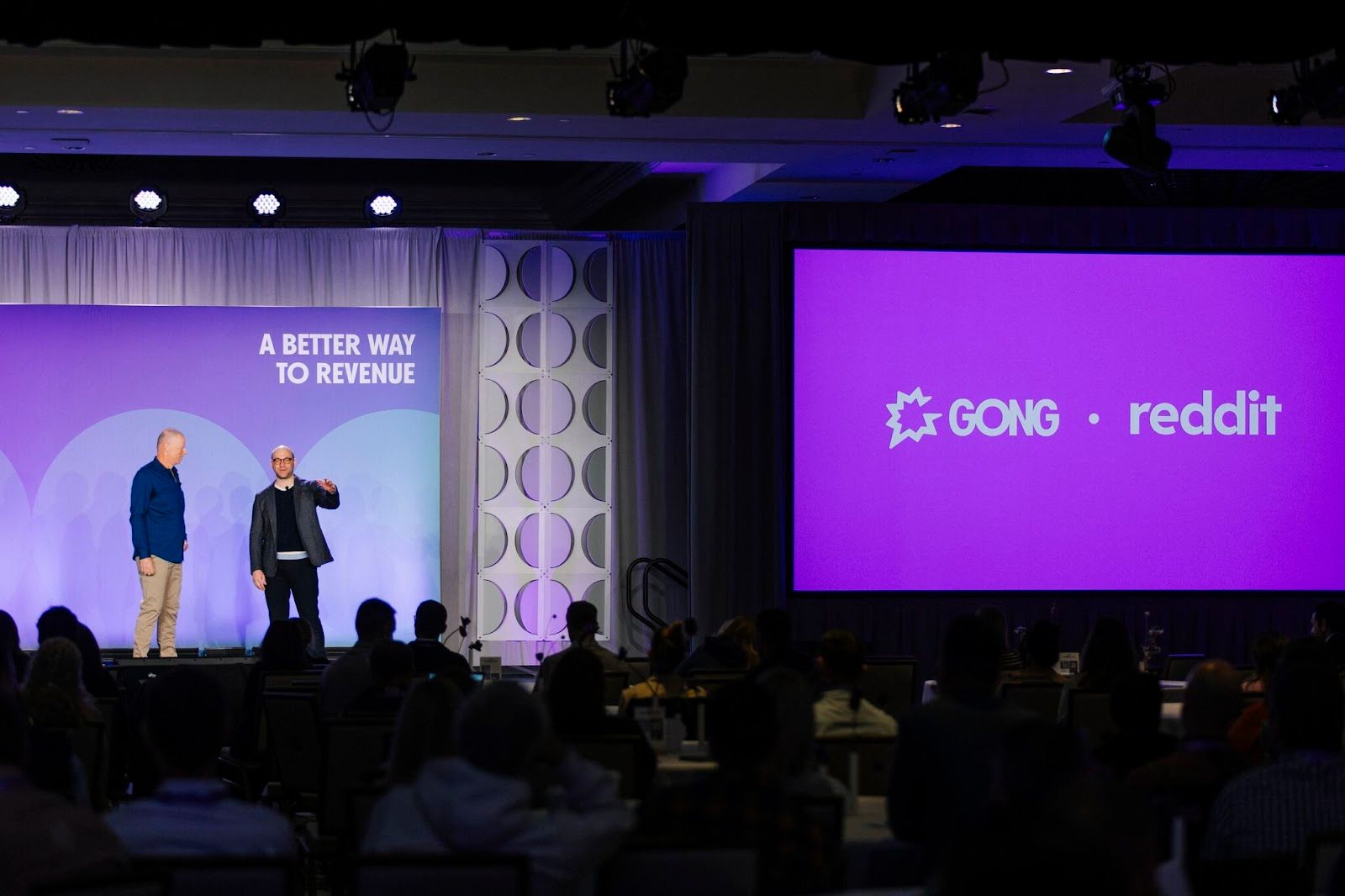 Two presenters on stage at Gong event discussing "A Better Way to Revenue" with GONG and Reddit logos displayed on screen