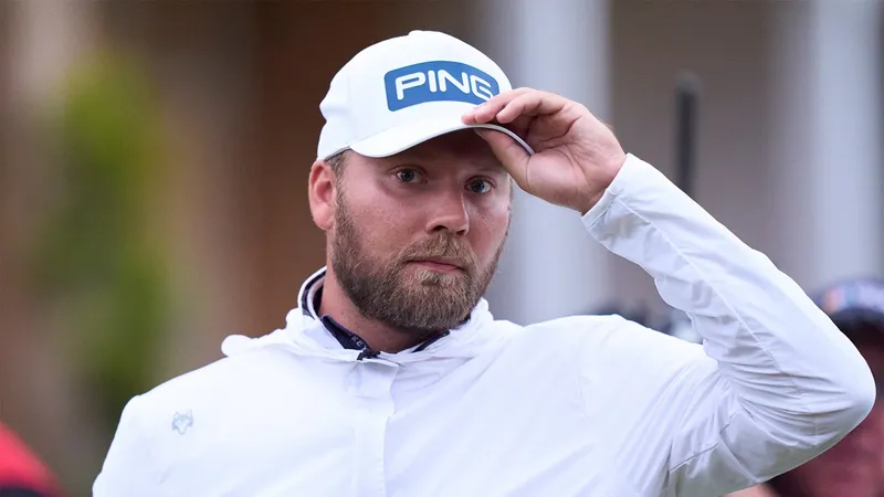 Dan Brown tijdens The Open Championship, met een witte PING-pet en witte jas