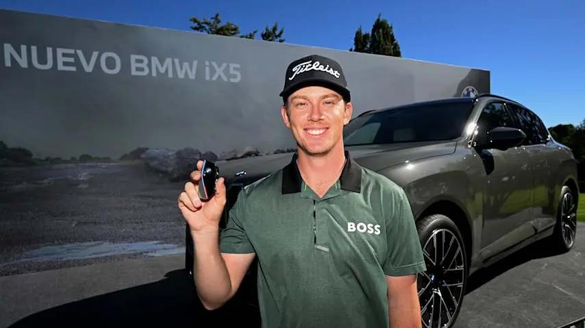 Daniel Hillier poseert bij zijn gewonnen BMW iX5 na zijn hole-in-one op de Open de España
