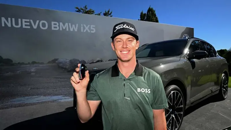 Daniel Hillier poseert bij zijn gewonnen BMW iX5 na zijn hole-in-one op de Open de España