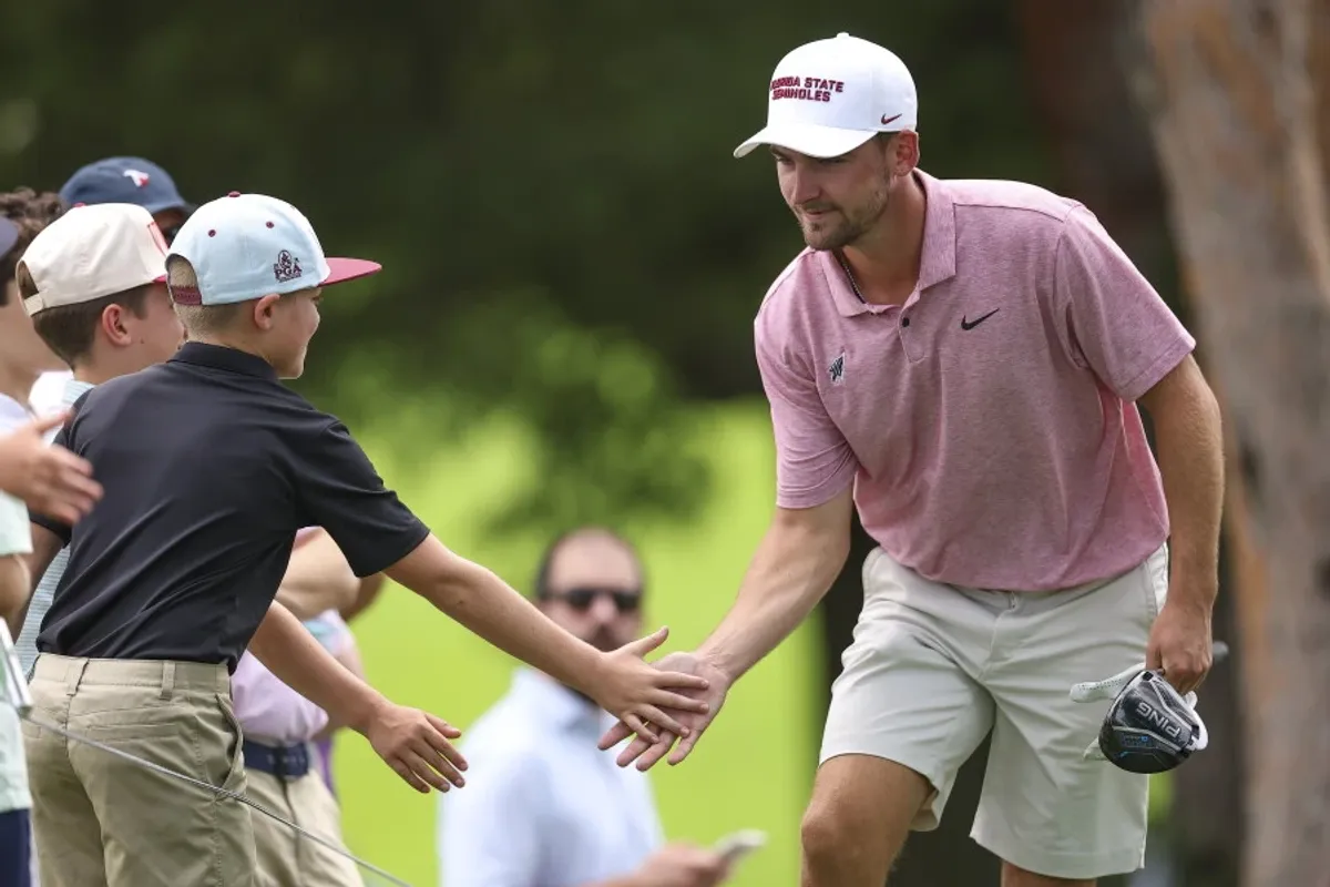 Jack Whaley krijgt high-fives van het publiek tijdens zijn kwartfinale op Merion Golf Club