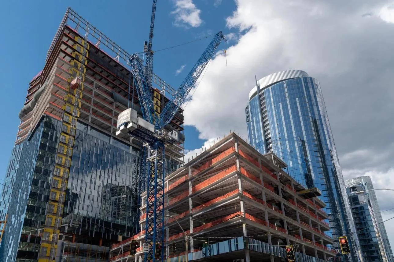 Tower under construction with a crane above the exposed frame