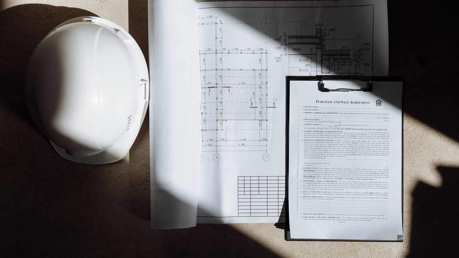Construction documents and a hard hat viewed from above on a jobsite