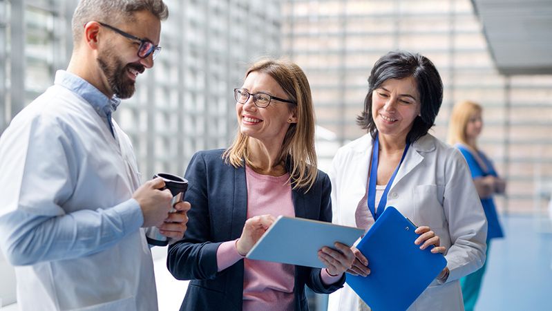 Healthcare and life sciences professionals reviewing information together in a bright clinical setting.