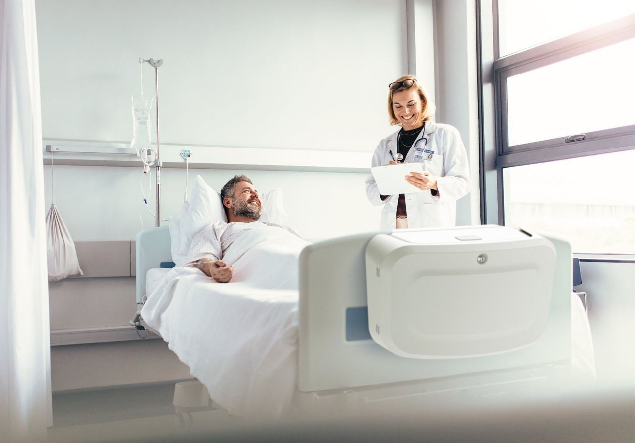 Patient and doctor, with the suitcase mounted at the foot of the bed