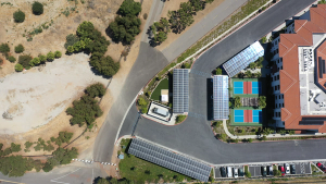 Aerial image of solar panels on the roof of various car ports in a parking lot