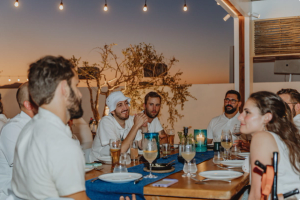 Wunder team sitting at a dinner table outside, wearing all white