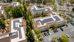 Aerial view of a commercial building with solar panels on its roof