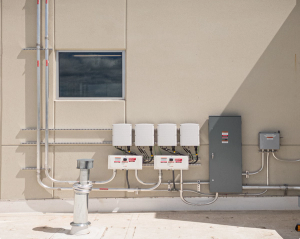 A variety of electrical equipment for the building including inverters, meters, conduit, breaker box