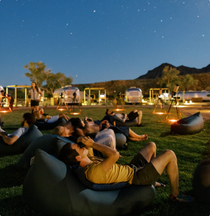 Image at night of people laying in grass and stargazing
