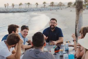 Image of Wunder team laughing around a table on a beach