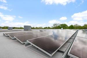 Solar panels on a roof with the sky visible above them