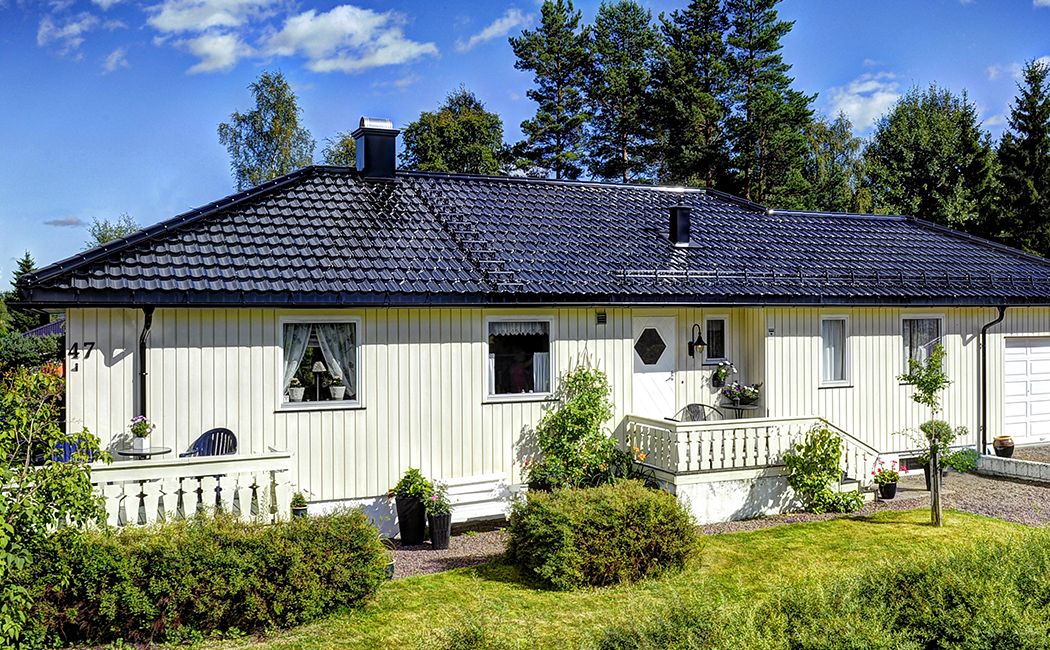 Et sort tak i høyglans på et hvitt hus