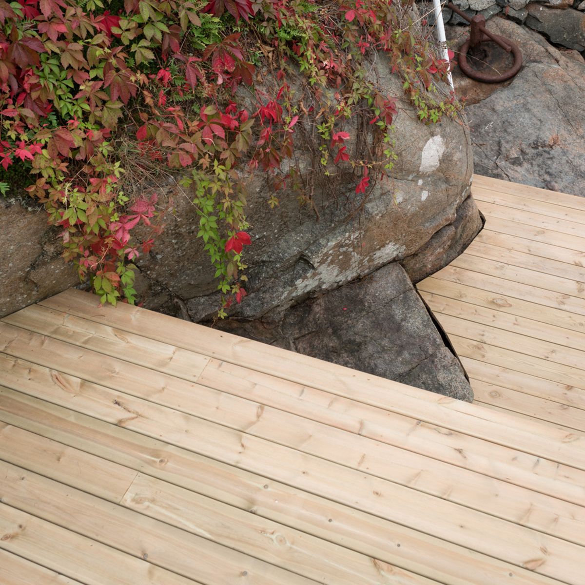 Tretrapp i hage laget av terrassebord som er tilpasset terrenget.