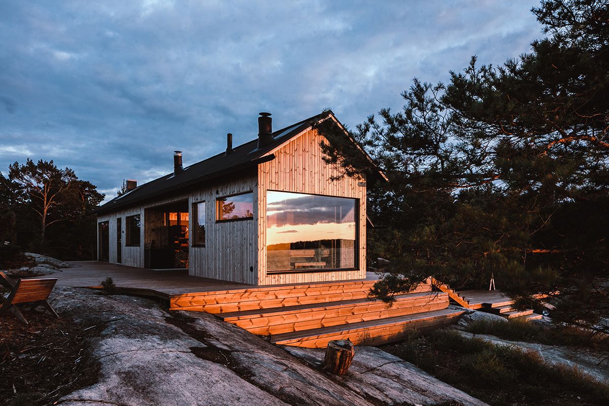 flott og moderne hytte ved sjøen, i solnedgang
