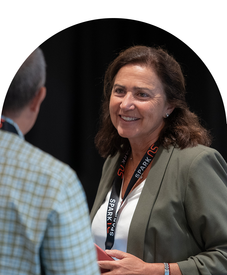 Attendees of a seminar sit at a table, looking focused and thoughtful