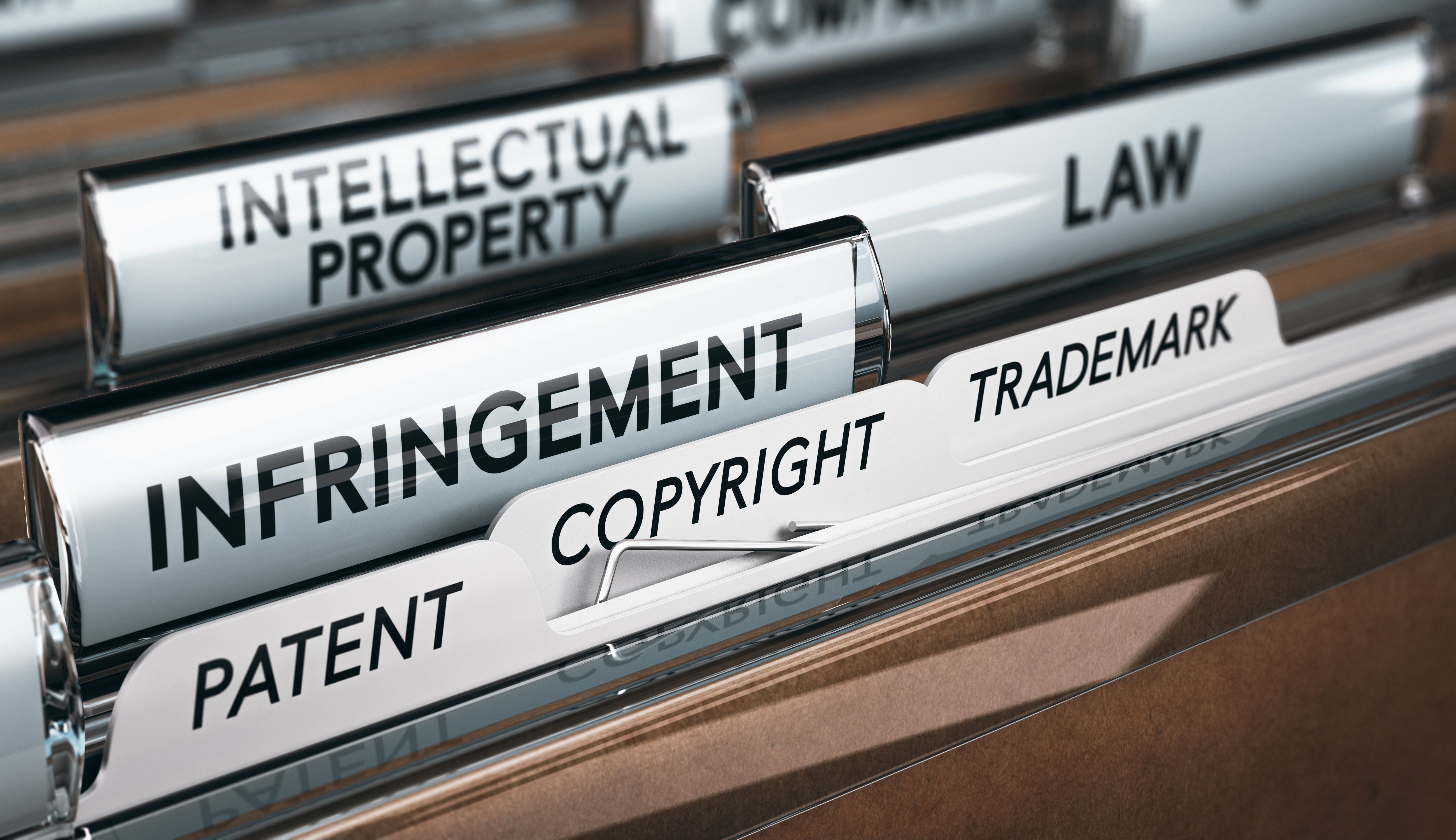 Close-up of labeled file folders related to intellectual property, including patent, copyright, trademark, infringement, and law.