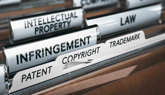 Close-up of labeled file folders related to intellectual property, including patent, copyright, trademark, infringement, and law.