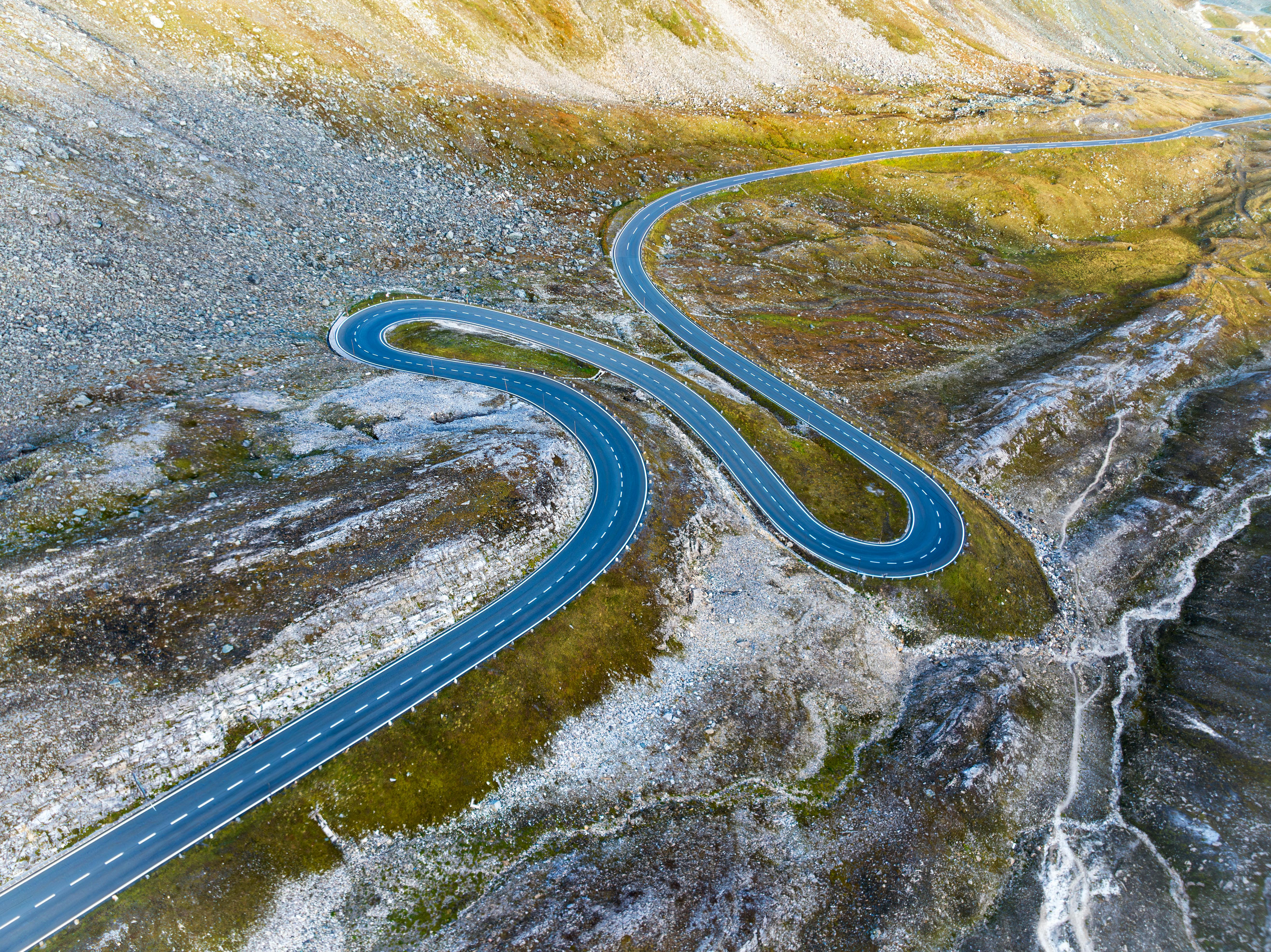 Drone capture of winding road through Hochtor's rocky landscape in Austria.