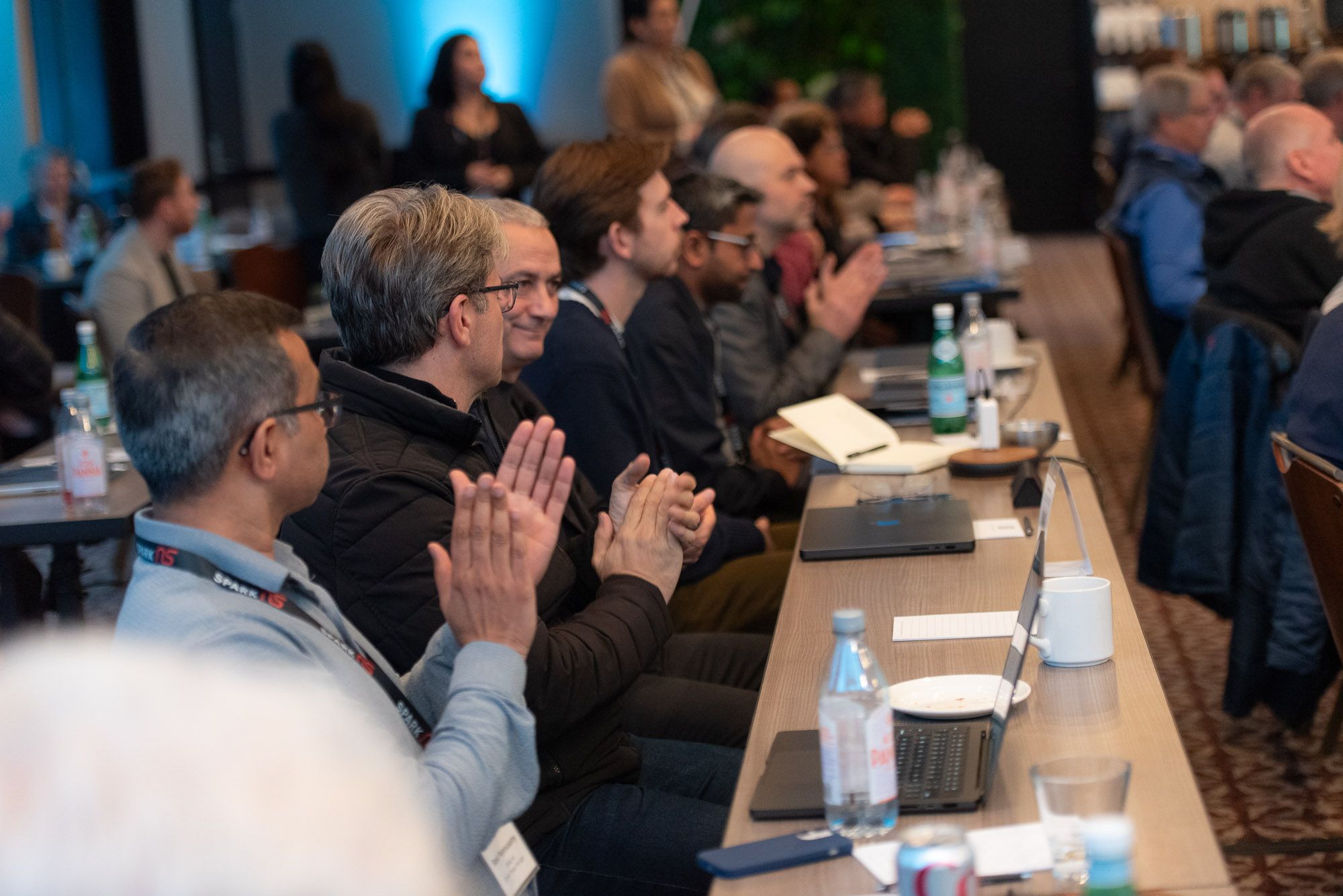 SPARK NS staff members, advisors, and principal investigators clapping during an in-person SPARK NS event.