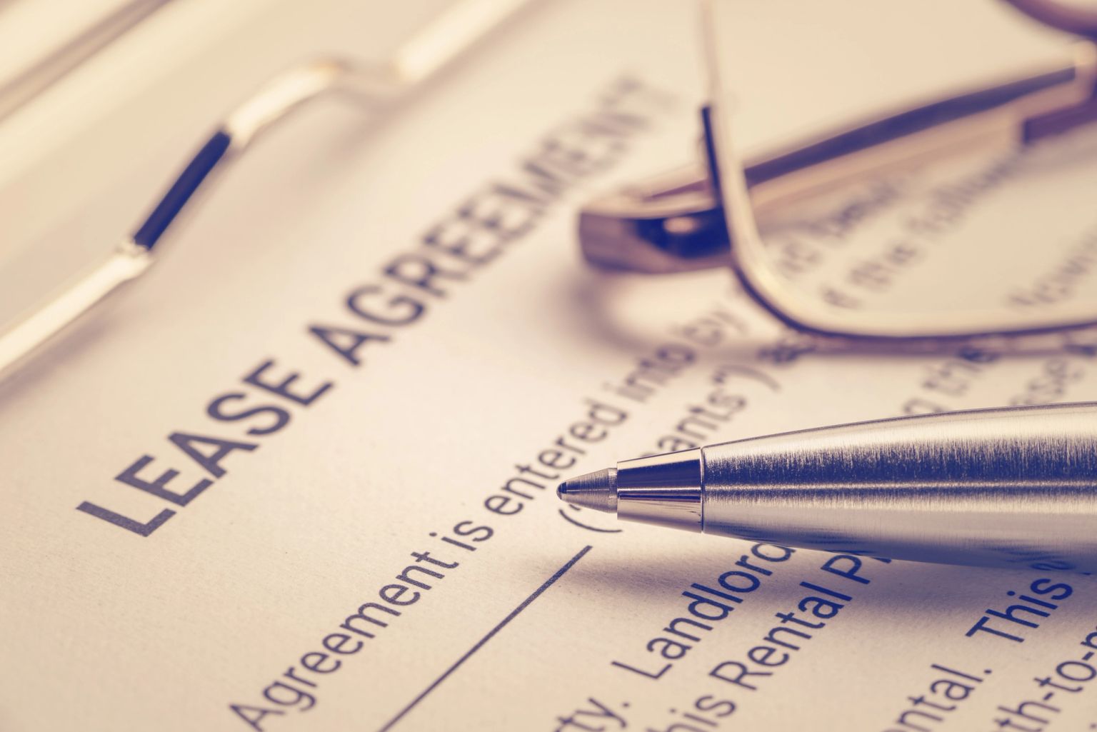 A lease agreement document with a pen and glasses.