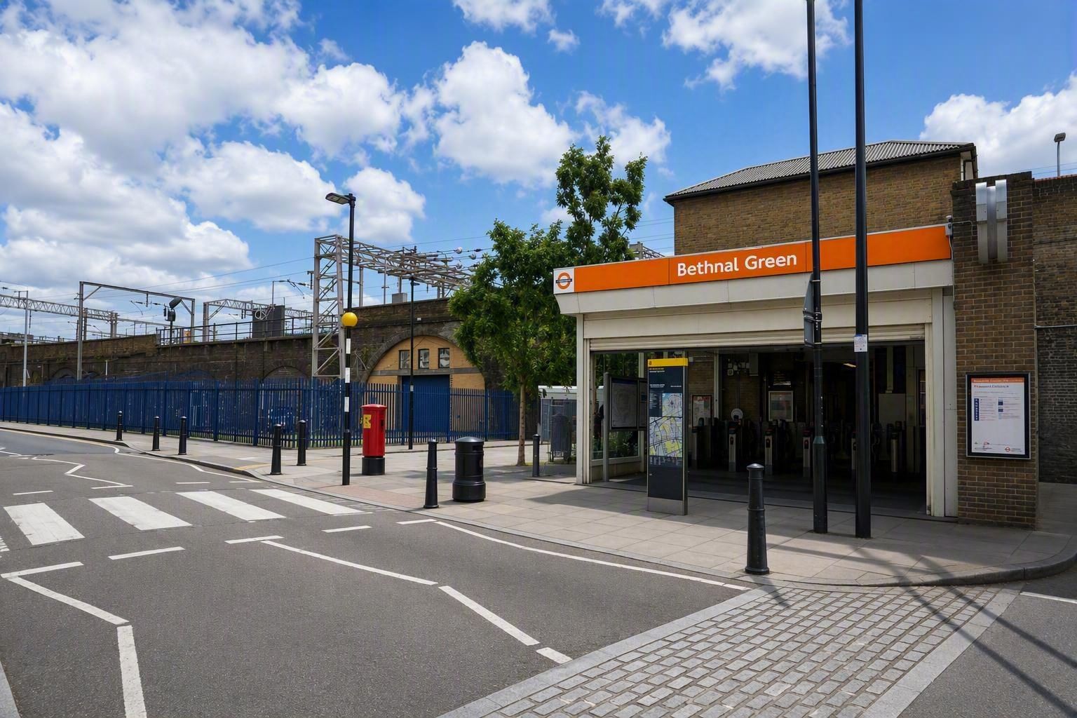 Entrance to Bow Bow Triangle Business Centre with a motorcyclist on the road and parked cars behind a fence.