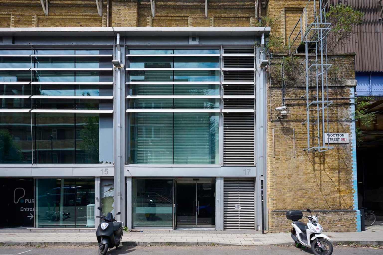 The front of an arch, with a fully glazed frontage and door allowing you to see into the arch interior.