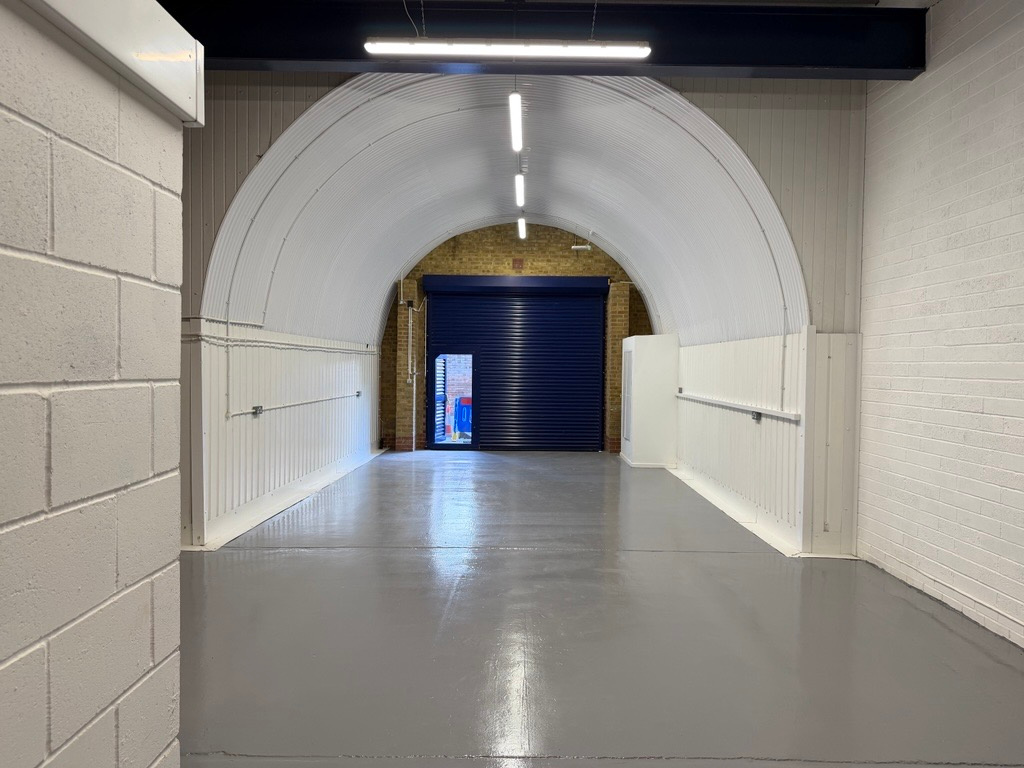 An empty arch with lining and a WC cubicle to the back