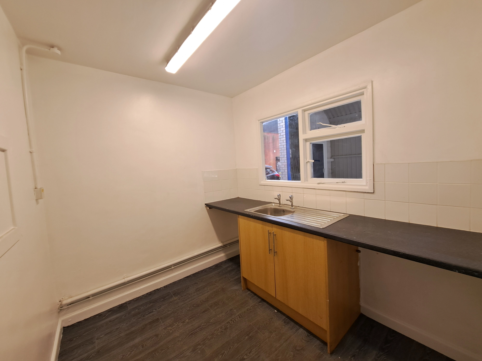 An empty arch with white lining and a WC cubicle to the front.