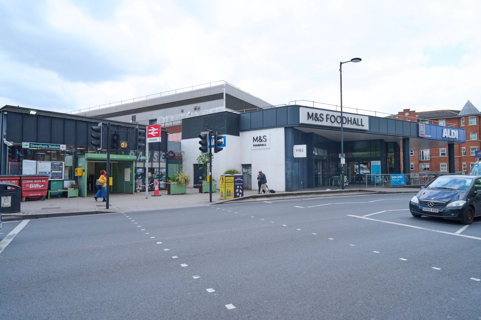 Streatham Station entrance and an M&S Foodhall with an Aldi sign visible on an urban street.