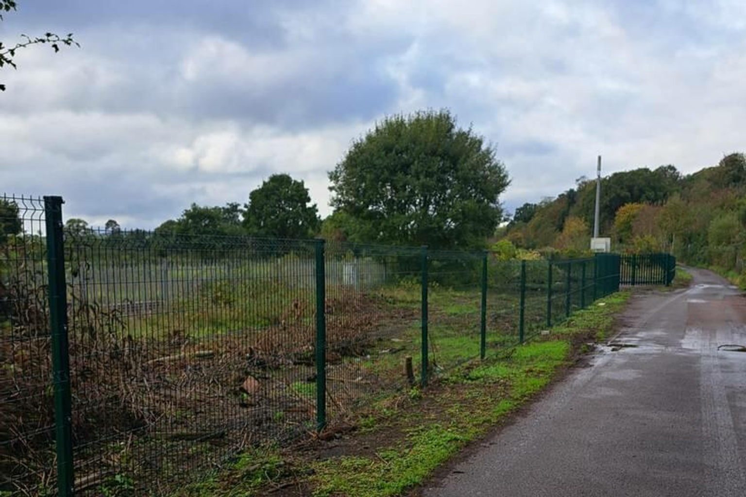 A large plot of land, with metal fencing around it.