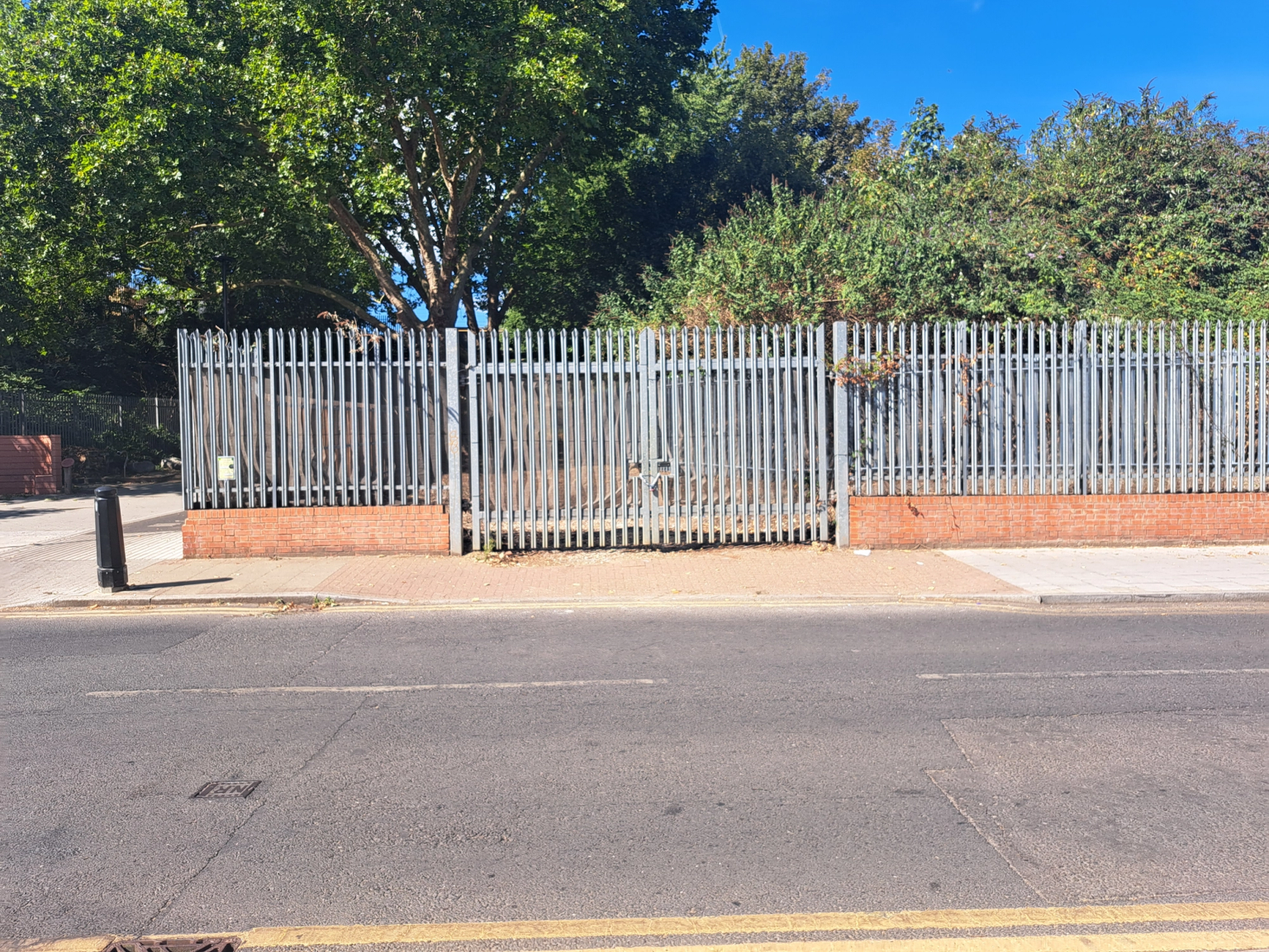 A large plot of land, with metal fencing around it.