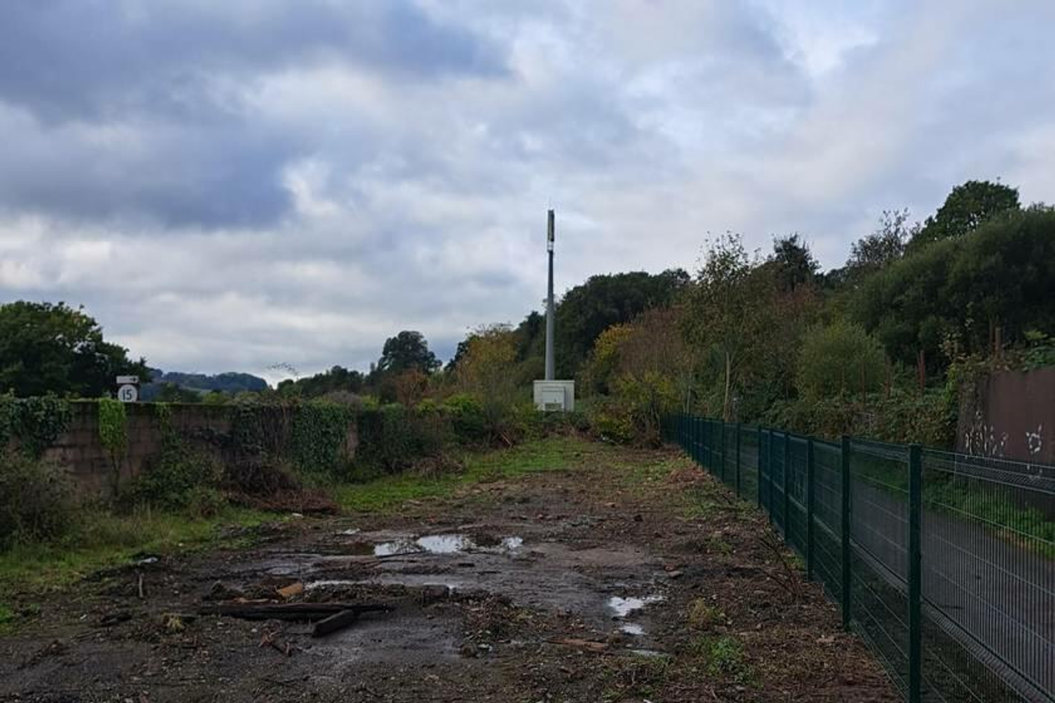 A large plot of land, with metal fencing around it.