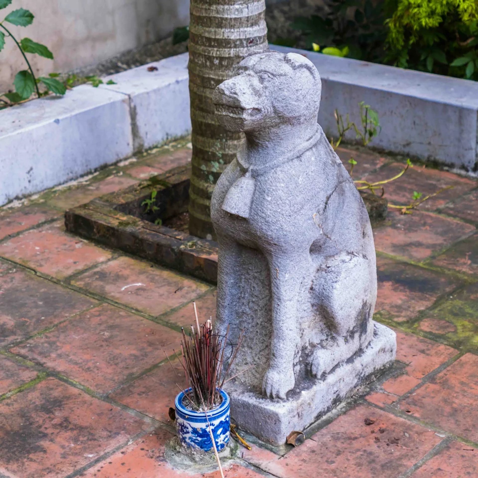 Tượng chó đá cổ thứ hai canh gác trước sân miếu