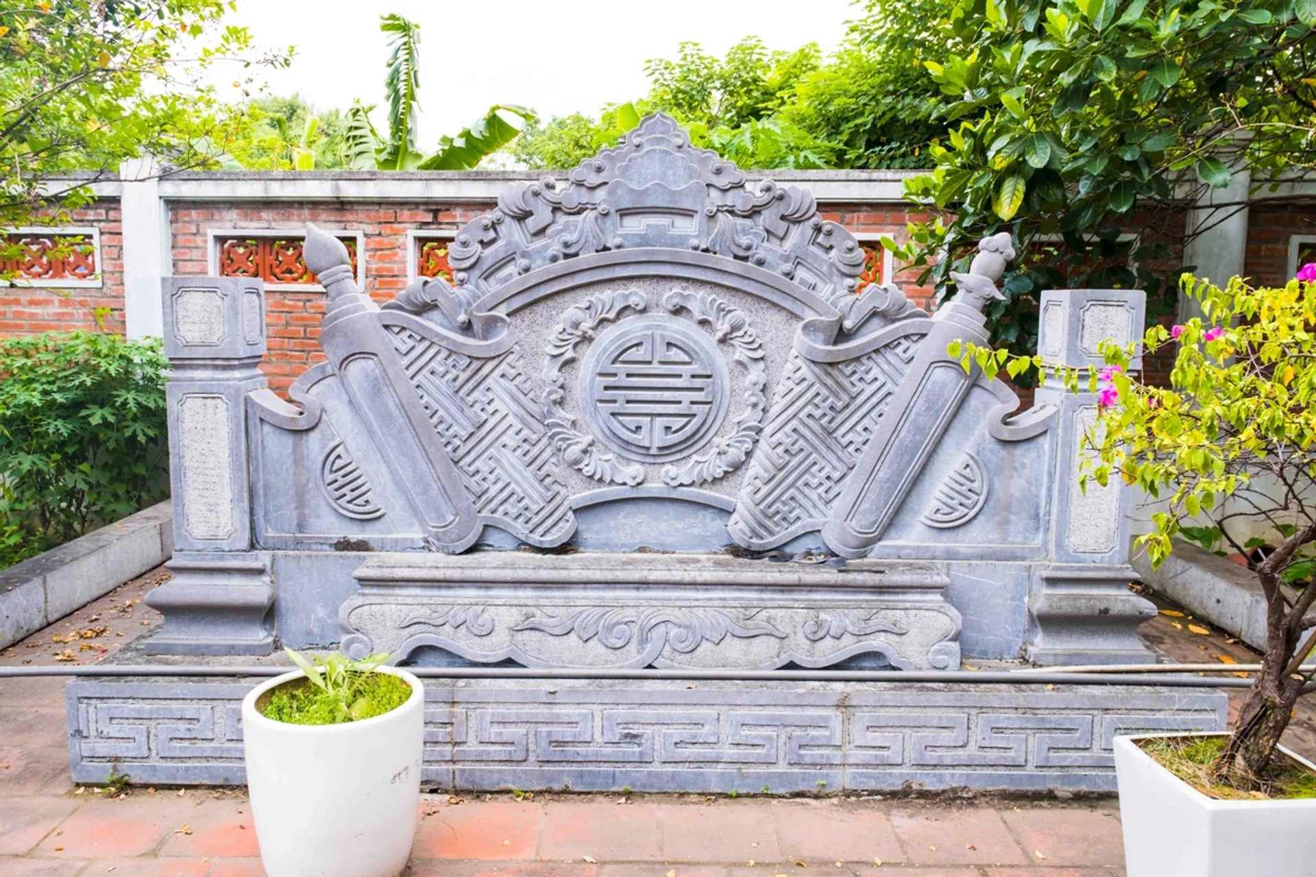 Bình phong đá chạm khắc hoa văn trước sân Miếu Vườn Chùa