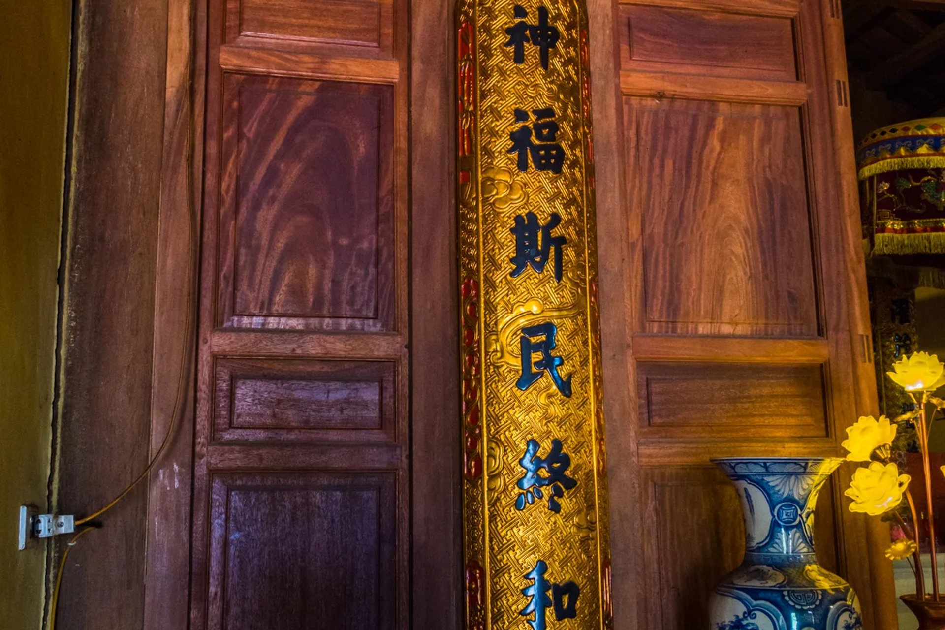 Đôi câu đối lòng máng ôm cột đình gỗ lim