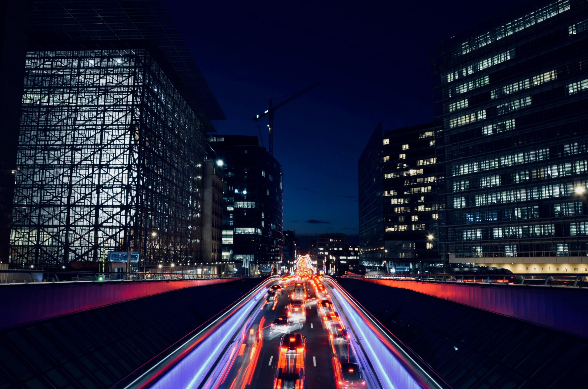 A busy street crossing the Brussels European District at night
